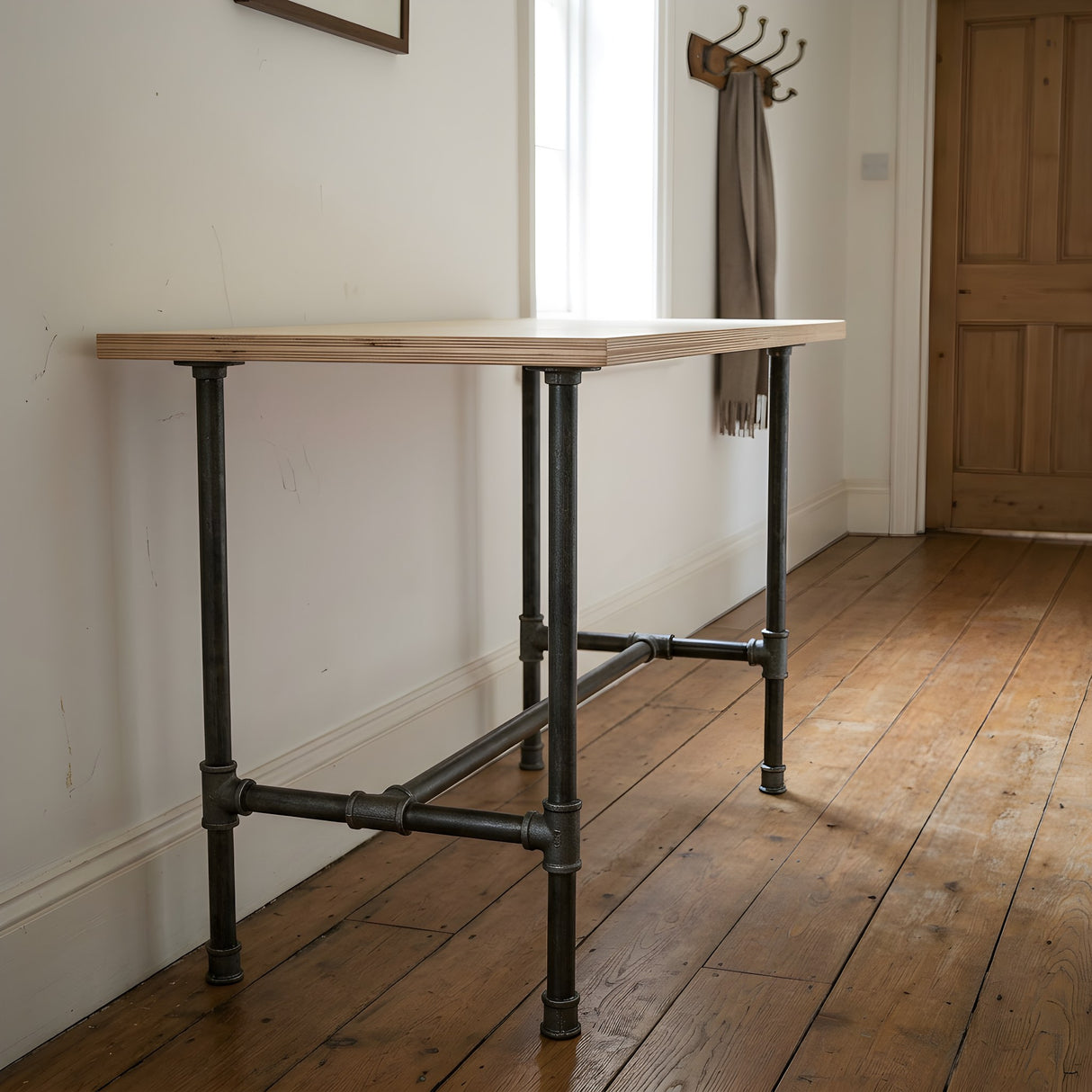 Piètement de table à manger en H, fonte et acier vernis Ø 27 mm, en situation sous un plateau en contreplaqué de bouleau