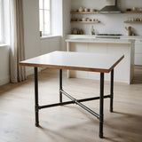Piètement de table à manger en croix, fonte et acier vernis Ø 34 mm, en situation sous un plateau blanc mat à chant bois