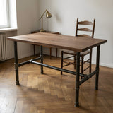 Piètement de table à manger en H, fonte et acier vernis Ø 34 mm, en situation sous un plateau en noyer massif