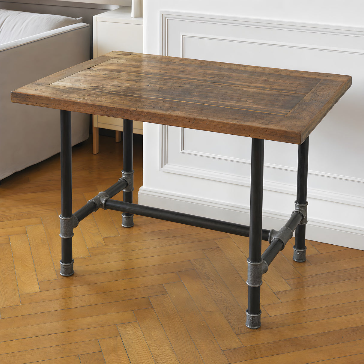 Piètement de table à manger en H, fonte et acier vernis Ø 42 mm, en situation sous un plateau fait d'une ancienne porte en bois