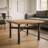 Piètement de table basse en croix, fonte et acier vernis Ø 34 mm, en situation sous un plateau en chêne massif clair