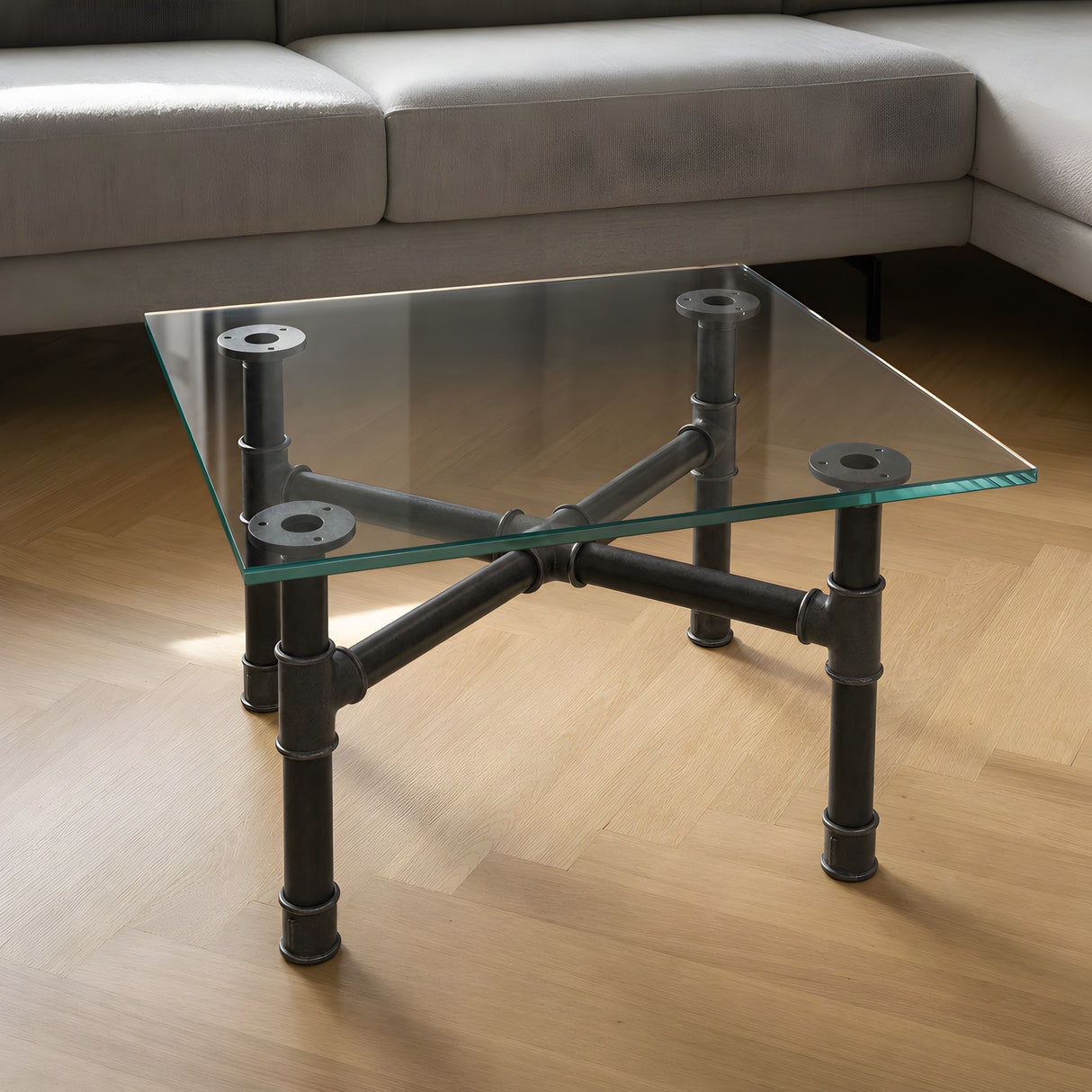 Piètement de table basse en croix, fonte et acier vernis Ø 34 mm, en situation sous un plateau en verre trempé