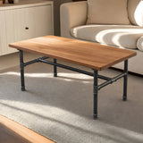 Piètement de table basse en H, fonte et acier noir verni Ø 27 mm, en situation sous un plateau en teck huilé