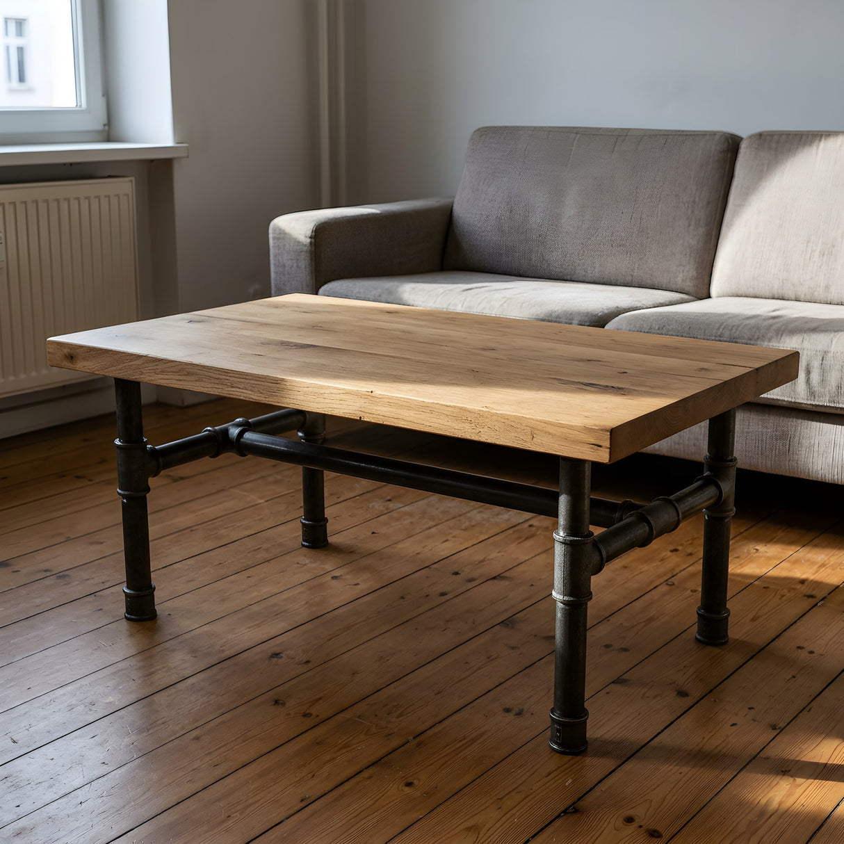 Piètement de table basse en H, fonte et acier vernis Ø 42 mm, en situation sous un plateau épais en chêne massif