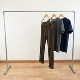 Portant galvanisé chargé de vêtements sur cintres