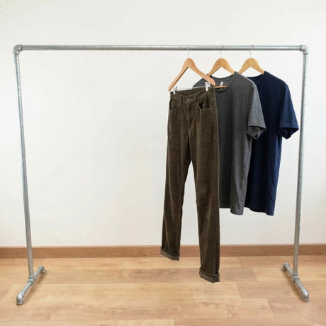 Portant galvanisé chargé de vêtements sur cintres