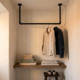 Portant plafond en tubes noirs dans un coin dressing, au-dessus d'une étagère en bois
