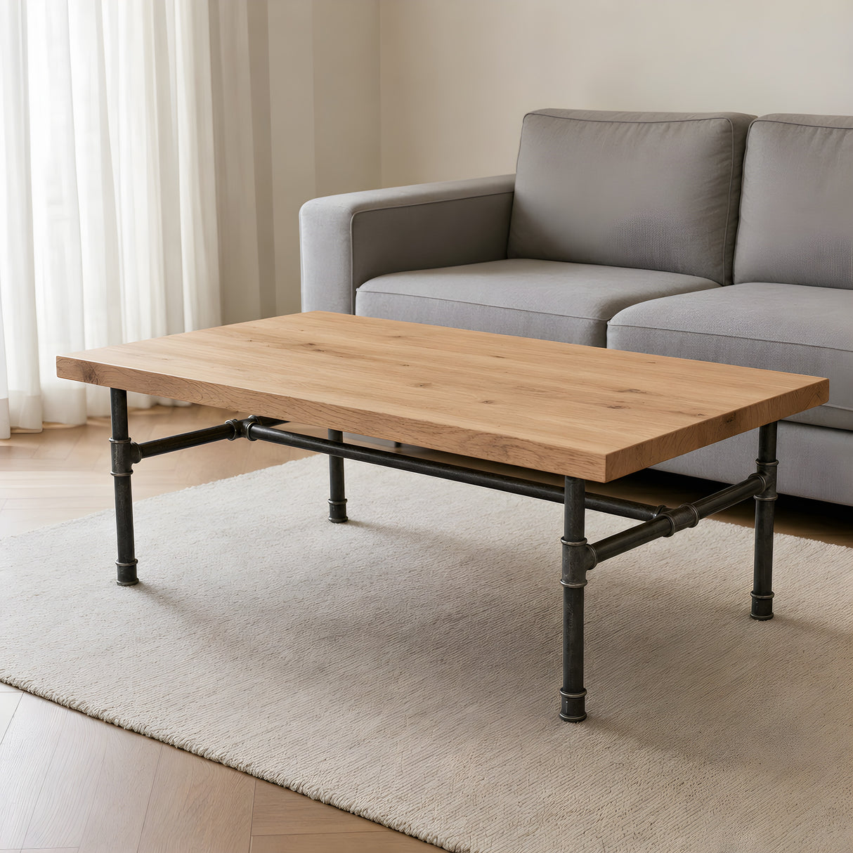 Table basse industrielle avec plateau en chêne clair sur piètement fonte en H, mise en situation (plateau non fourni)