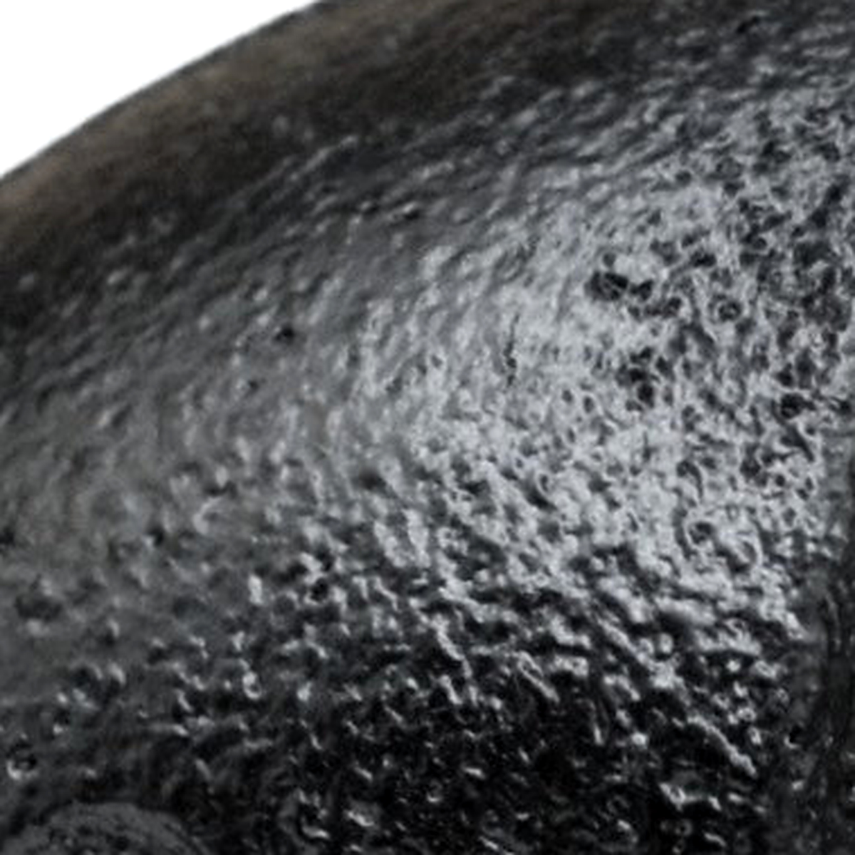 Gros plan sur la peinture noire mate et grenue d'un raccord en fonte
