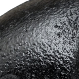 Gros plan sur la peinture noire mate et grenue d'un raccord en fonte